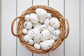 Image showing Basket of white dotted Easter eggs in brown wicker basket