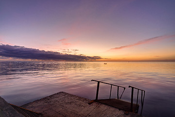 Image showing view of the evening sea from the pier, a ladder descends into the sea