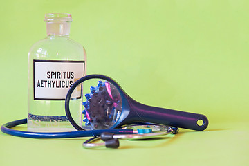 Image showing Ethanol in a bottle on the table with of microscope virus close up, stethoscope and loupe. Coronavirus concept