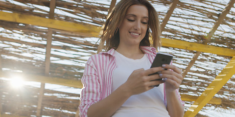 Image showing Smartphone Woman Texting On Cell Phone At Beach