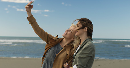 Image showing Girls having time and taking selfie on a beach