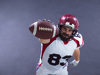 Image showing american football player showing football to camera