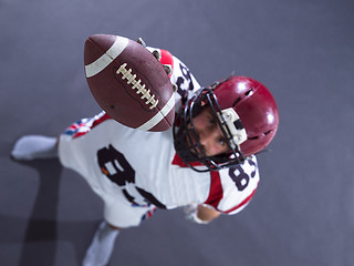 Image showing american football player showing football to camera