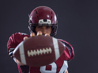 Image showing american football player showing football to camera