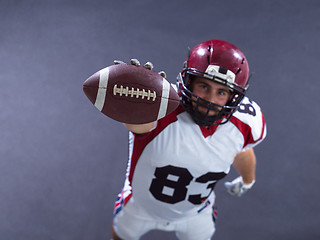 Image showing american football player showing football to camera