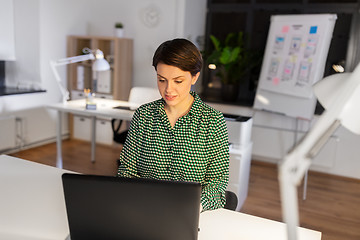 Image showing businesswoman working on laptop at night office