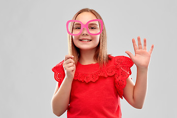 Image showing smiling girl with big paper glasses waving hand