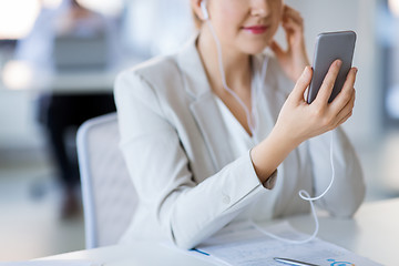 Image showing businesswoman with earphones and smartphone