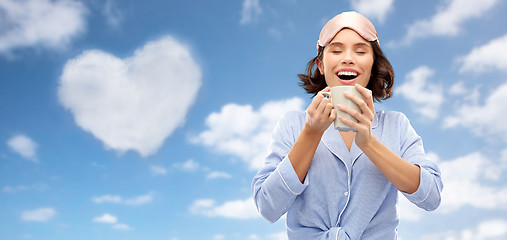 Image showing woman in pajama and sleeping mask drinking coffee