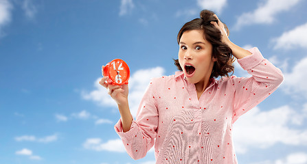 Image showing shocked young woman in pajama with alarm clock