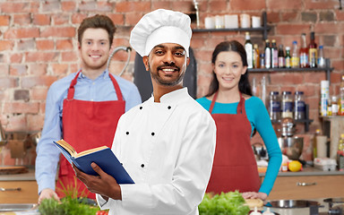 Image showing male indian chef reading cookbook at cooking class