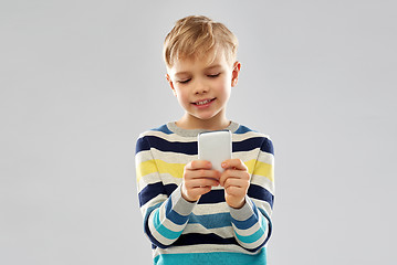 Image showing little boy in striped pullover using smartphone