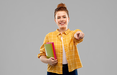 Image showing teenage student girl with books pointing to you