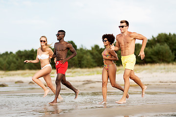 Image showing happy friends running on summer beach