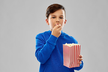 Image showing boy in blue hoodie eating popcorn