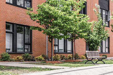 Image showing Green trees in front of a modern brick building