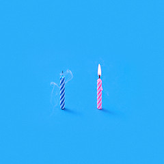 Image showing Two cake\'s candles one burning and another is blown out.