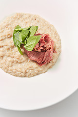 Image showing Close-up view oatmeal porridge with lowfat ham and fresh spinach.