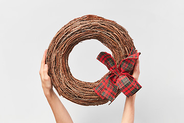 Image showing Handcraft round wreath from twigs in the woman\'s hands.