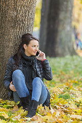 Image showing Woman with a Mobile in a Forest in the Autumn