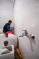 Image showing professional plumber working in a bathroom