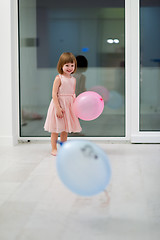 Image showing cute little girl playing with balloons