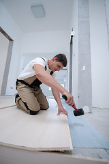 Image showing Professional Worker Installing New Laminated Wooden Floor