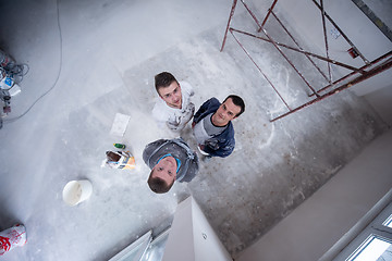 Image showing top view of Workers and builders with dirty uniform in apartment