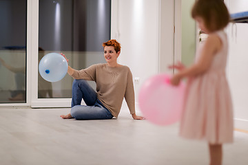 Image showing mother and cute little daughter playing with balloons