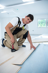 Image showing Professional Worker Installing New Laminated Wooden Floor