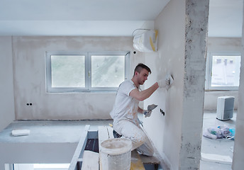 Image showing construction worker plastering on gypsum walls