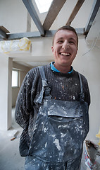 Image showing portrait of construction worker with dirty uniform in apartment