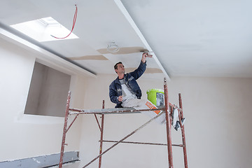 Image showing construction worker plastering on gypsum ceiling