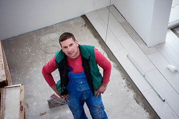 Image showing worker installing the ceramic wood effect tiles on the floor