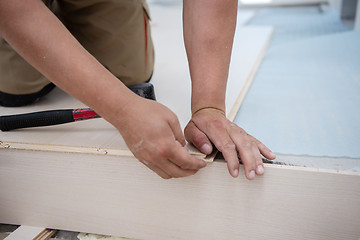 Image showing Worker Installing New Laminated Wooden Floor