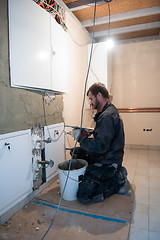 Image showing Worker plastering the wall by concrete