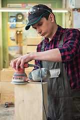 Image showing Worker grinds the wood box