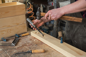 Image showing Carpenter working with a chisel