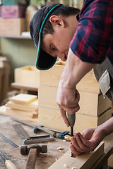 Image showing Carpenter working with a chisel