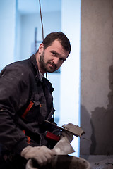 Image showing Worker plastering the wall by concrete