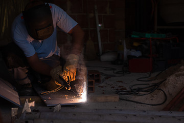 Image showing welder with protective mask welding steel