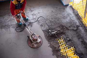 Image showing worker performing and polishing sand and cement screed floor