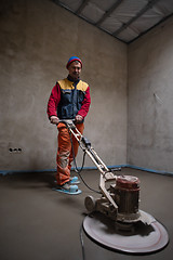 Image showing worker performing and polishing sand and cement screed floor