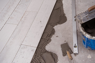 Image showing Ceramic wood effect tiles and tools for tiler on the floor