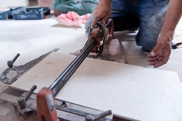 Image showing worker cutting the ceramic wood effect tiles