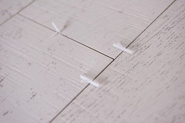 Image showing Ceramic wood effect tiles and tools for tiler on the floor