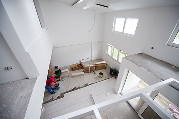 Image showing worker installing the ceramic wood effect tiles on the floor