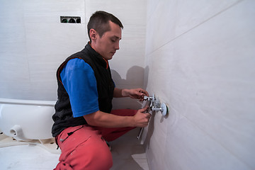 Image showing professional plumber working in a bathroom