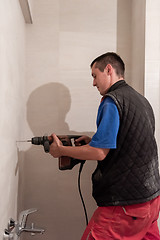 Image showing construction worker drilling holes in the bathroom