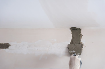 Image showing construction worker plastering on gypsum walls